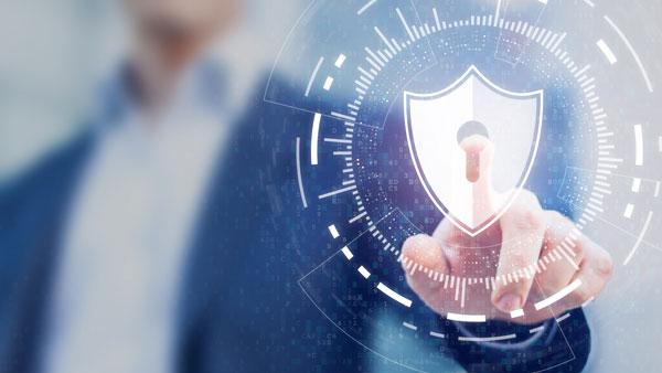 Heart-Technologies-Peoria-IL-IT-Networking_Cybersecurity Hand touching a digital shield icon for cybersecurity.