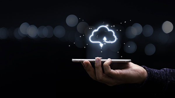Hand holding phone with glowing cloud.
